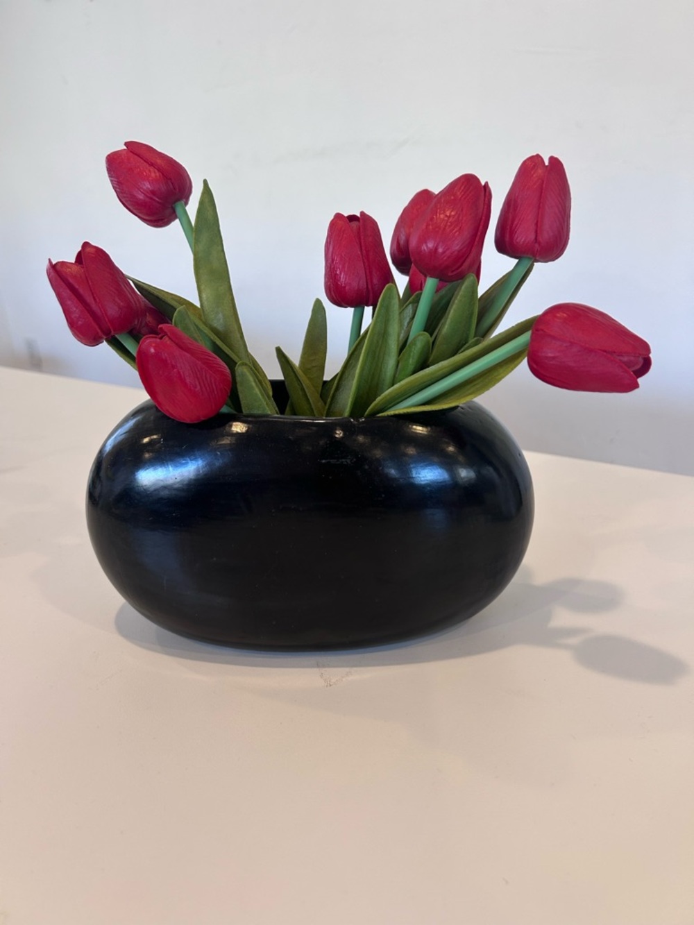 Black Ceramic Oval Vase with Red Tulip Arrangement